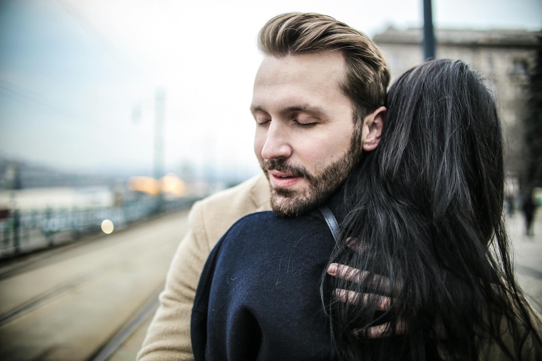 selective focus back view photo of woman hugging man